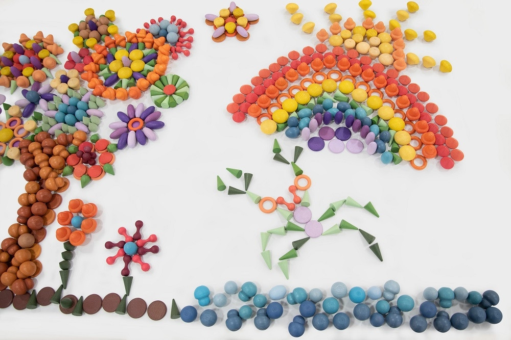 building blocks arranged to create a picture of a tree, flowers and rainbow