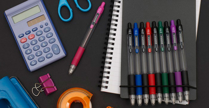 pens on a desk with other stationery